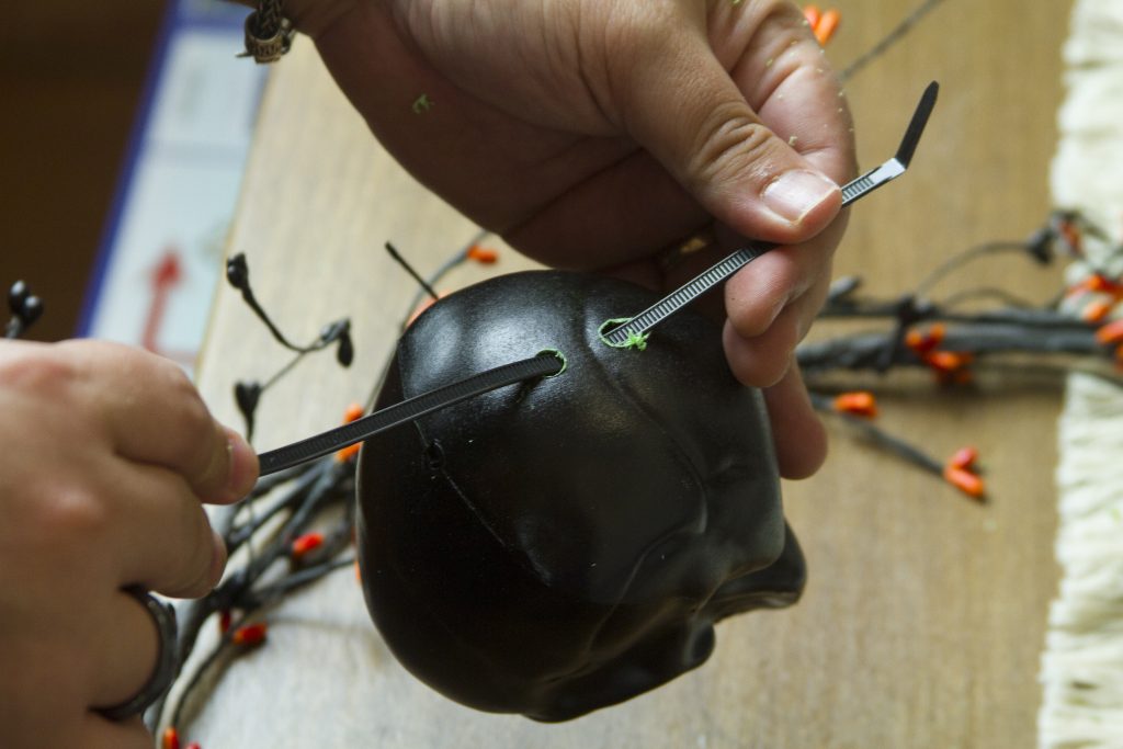 zip tie through holes drilled in fake skull
